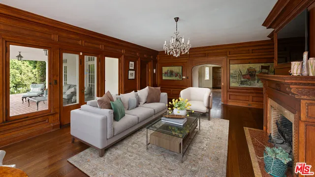 a living room with furniture a chandelier and a flat screen tv