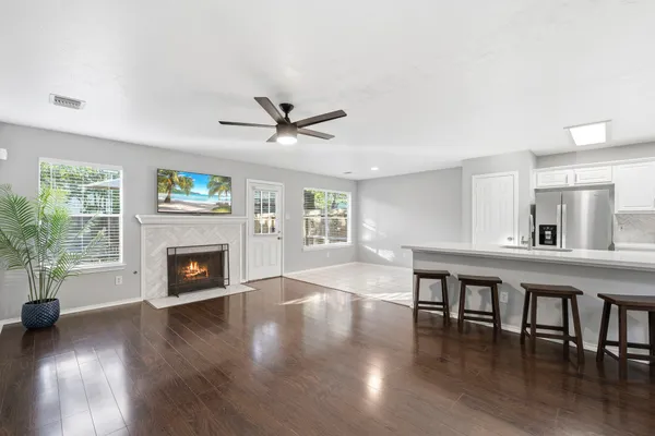 an empty room with windows fireplace and wooden floor