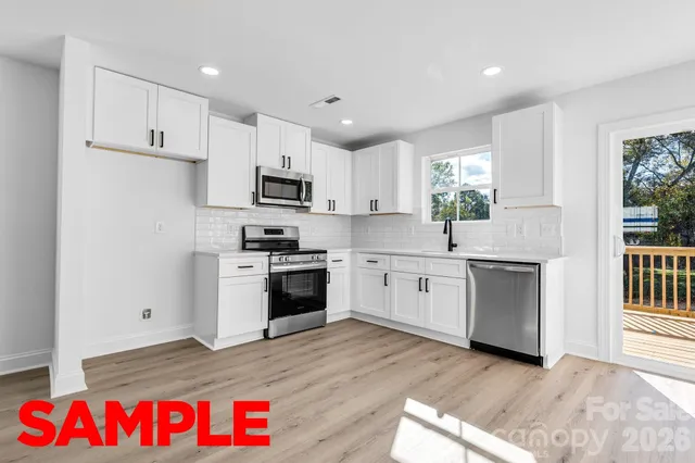 a kitchen with granite countertop white cabinets and white appliances