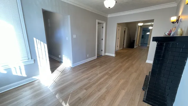 a view of a hallway with wooden floor and staircase