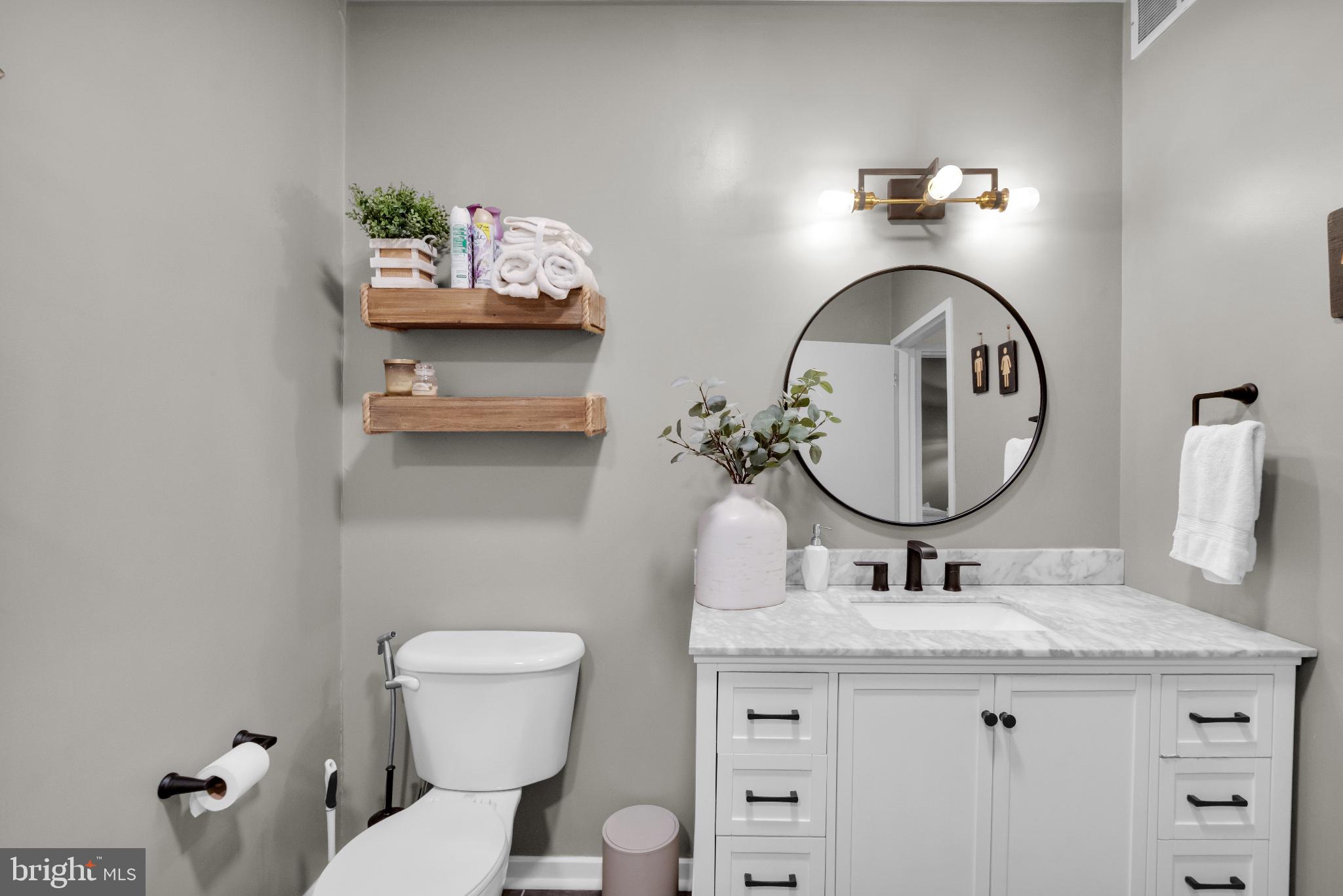 182 Gay Street, Unit 104 Philadelphia, PA 19128 - Photo 11 of 23 a bathroom with a toilet sink and mirror