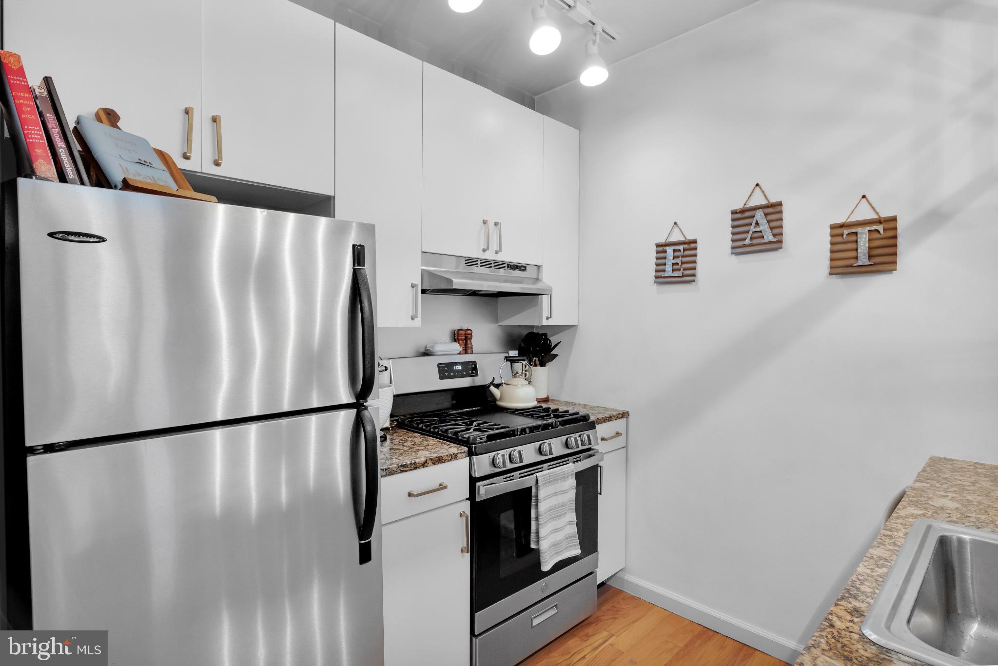 182 Gay Street, Unit 104 Philadelphia, PA 19128 - Photo 14 of 23 a kitchen with stainless steel appliances a refrigerator a stove a sink and a refrigerator