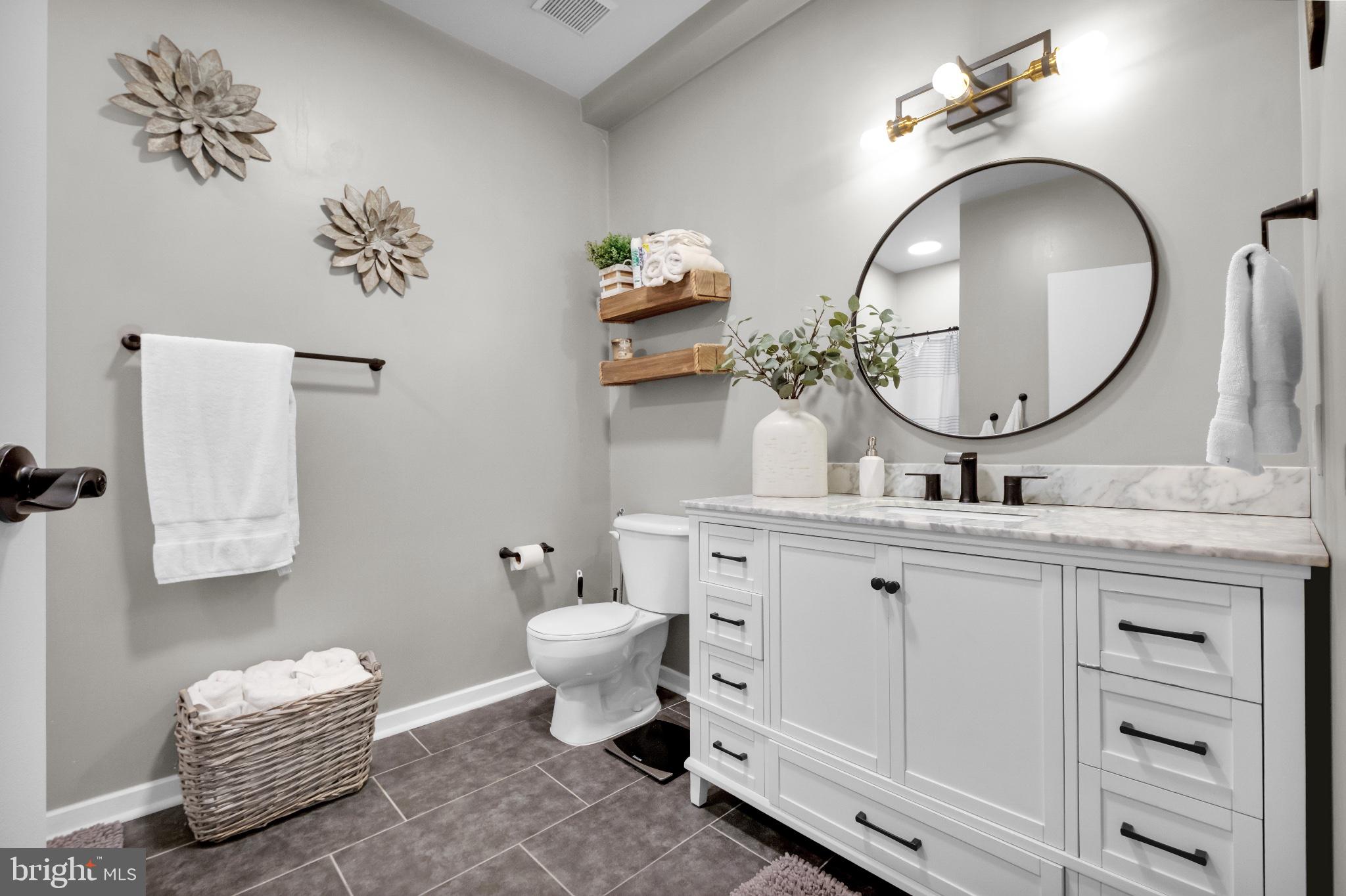182 Gay Street, Unit 104 Philadelphia, PA 19128 - Photo 8 of 23 a bathroom with a toilet a sink and mirror