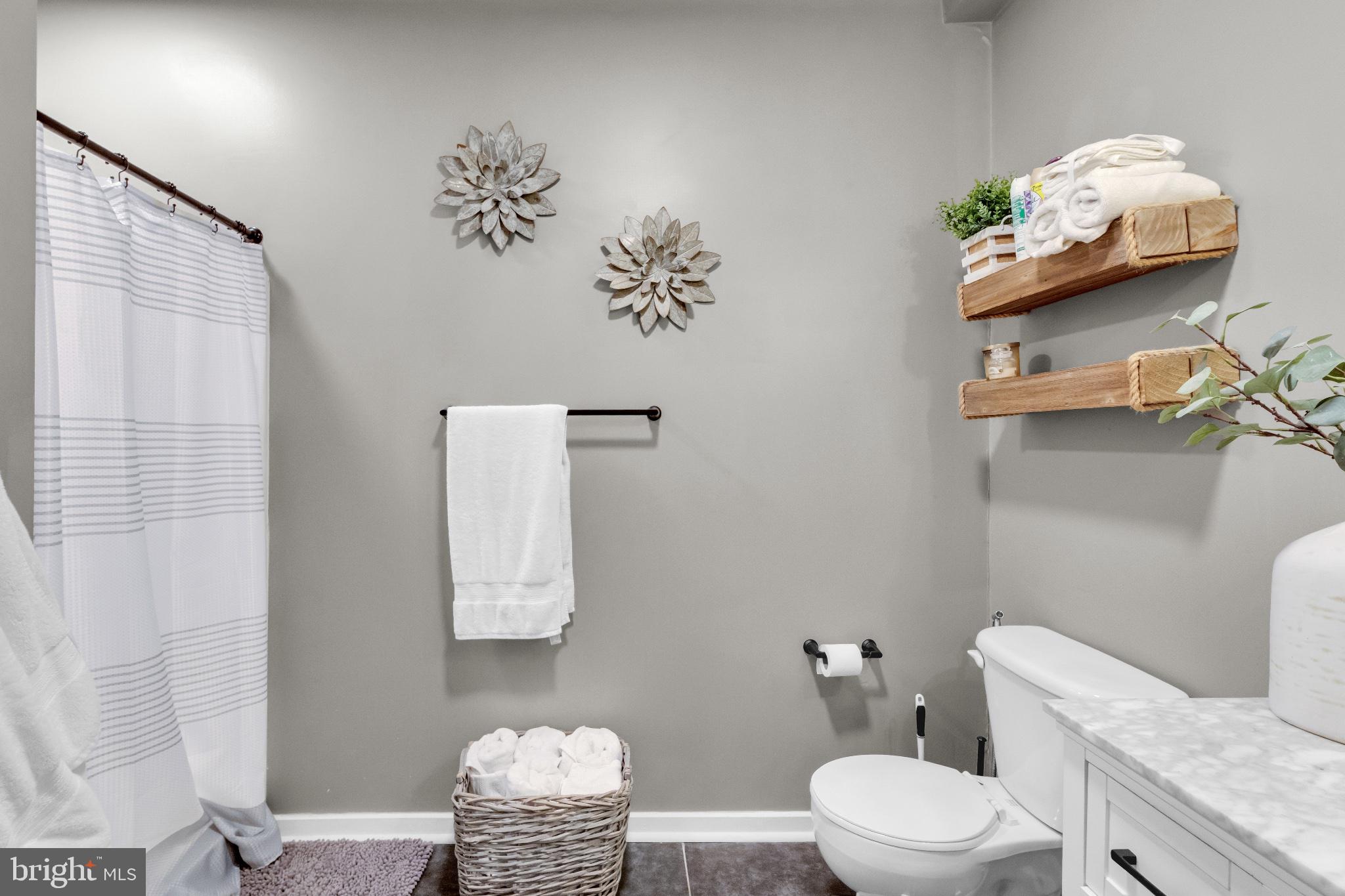 182 Gay Street, Unit 104 Philadelphia, PA 19128 - Photo 9 of 23 a bathroom with a sink a toilet and a shower curtain