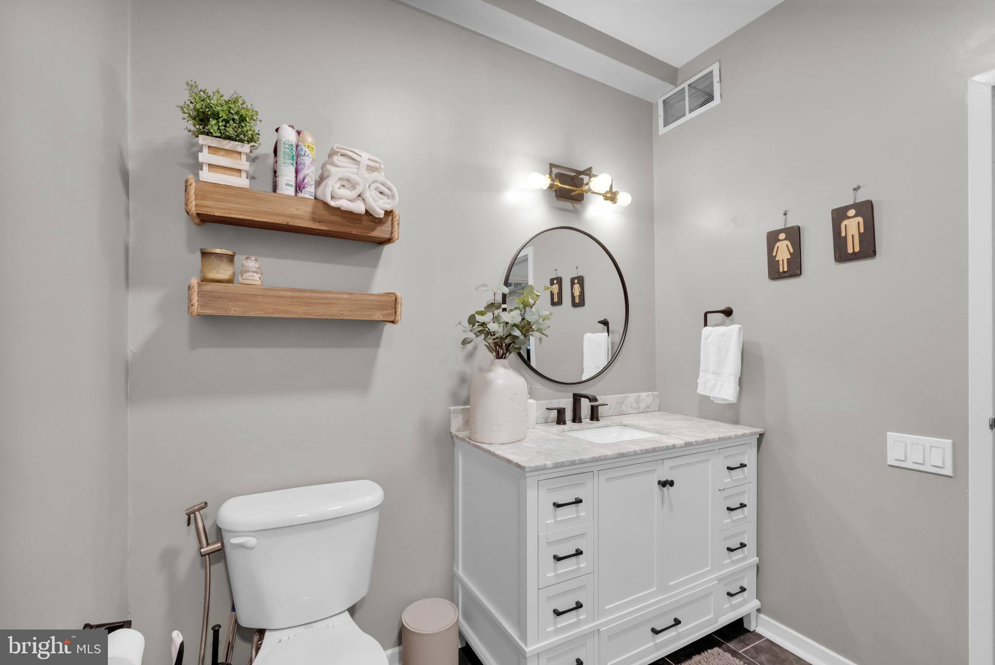 182 Gay Street, Unit 104 Philadelphia, PA 19128 - Photo 10 of 23 a bathroom with a toilet sink and mirror