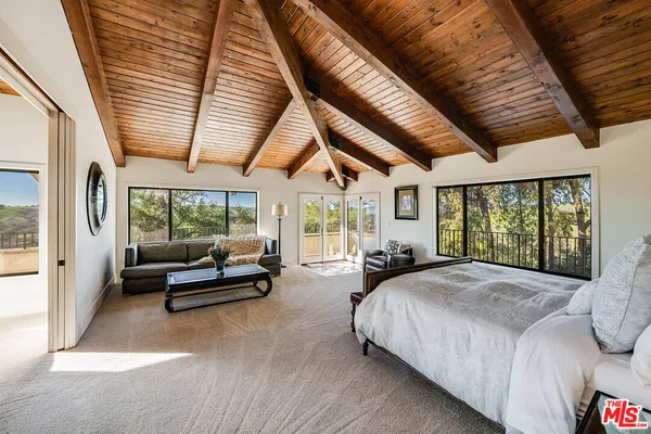 a living room with furniture a flat screen tv and a large window