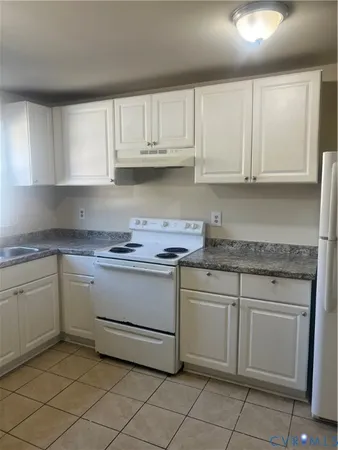 a kitchen with granite countertop white cabinets and white appliances
