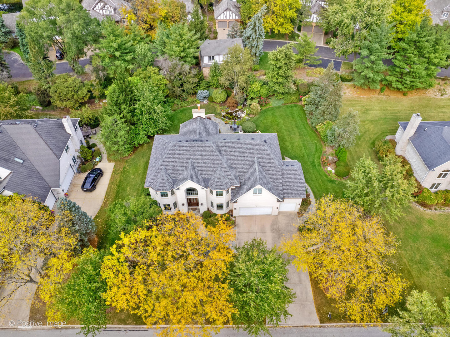 an aerial view of residential house with outdoor space and trees all around