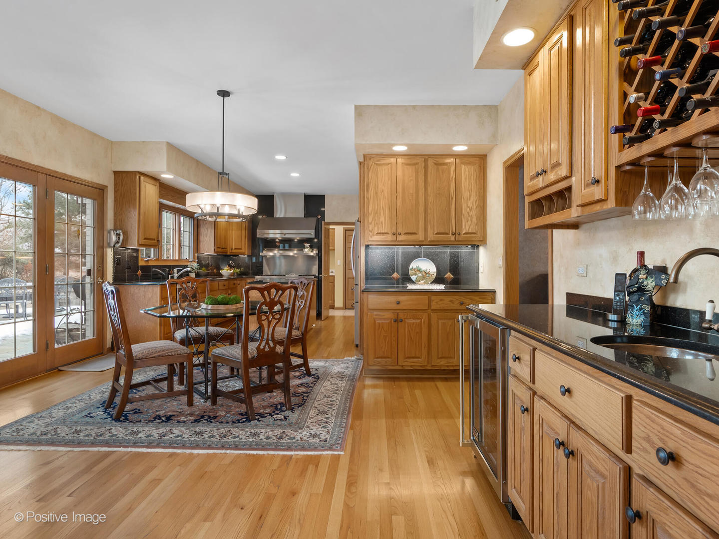 15-w601 81st Street Burr Ridge, IL 60527 - Photo 11 of 42 a kitchen with stainless steel appliances granite countertop a table chairs in it and wooden floors