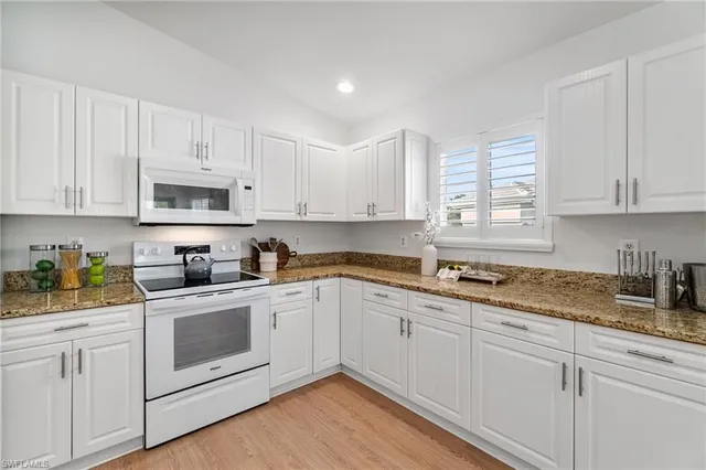 a kitchen with a sink cabinets and wooden floor