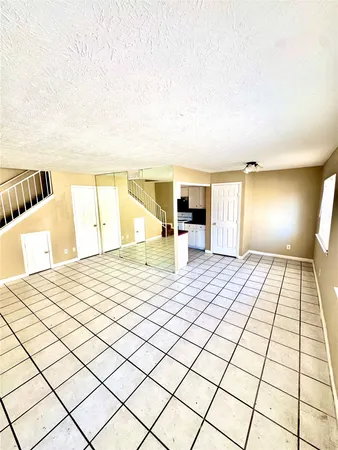 a bed room with a bed and a view of kitchen