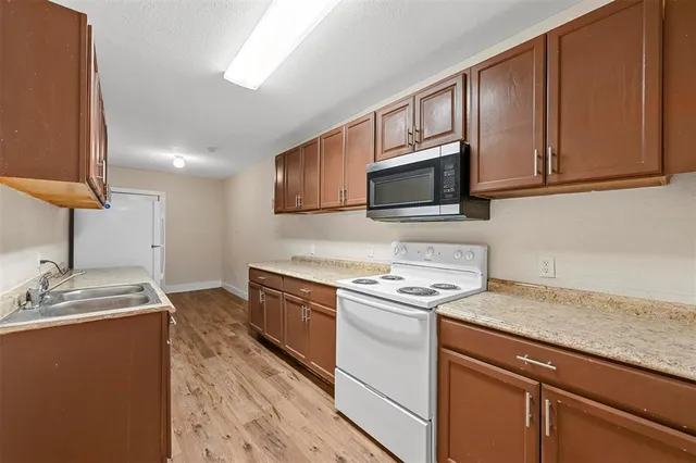 a kitchen with stainless steel appliances granite countertop a sink stove microwave and refrigerator
