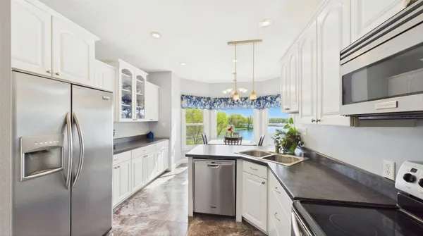 a kitchen with stainless steel appliances granite countertop a stove a refrigerator and a sink