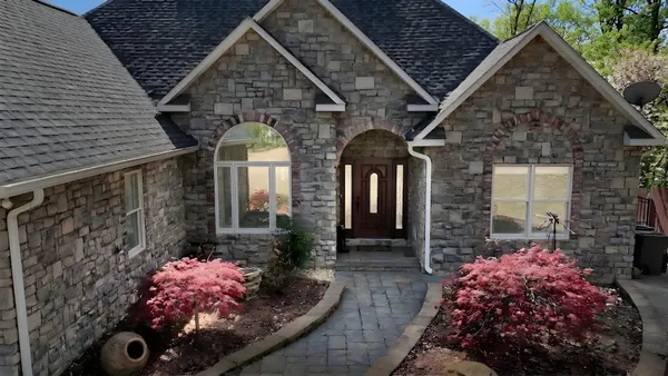 a living room with furniture and a large window with potted plants