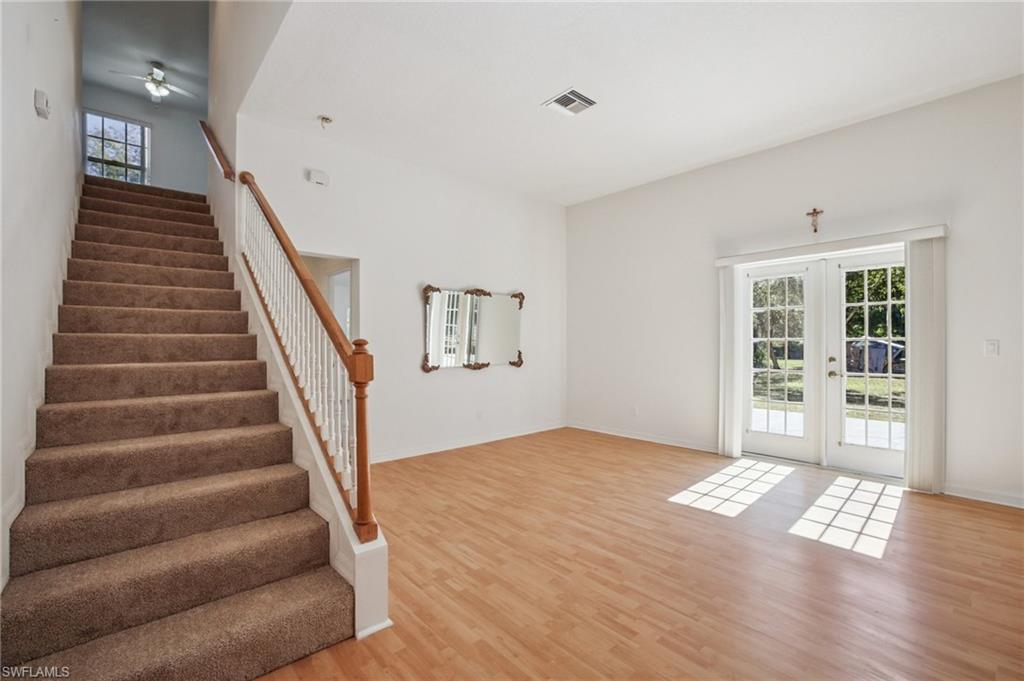 5348 Cypress Lane Naples, FL 34113 - Photo 6 of 28 a view of an empty room with wooden floor and stairs