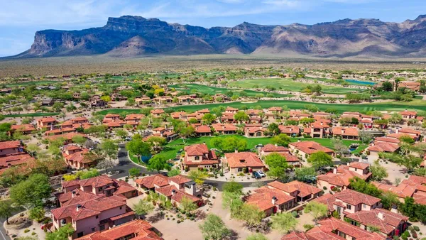 an aerial view of a house with a garden and mountain view