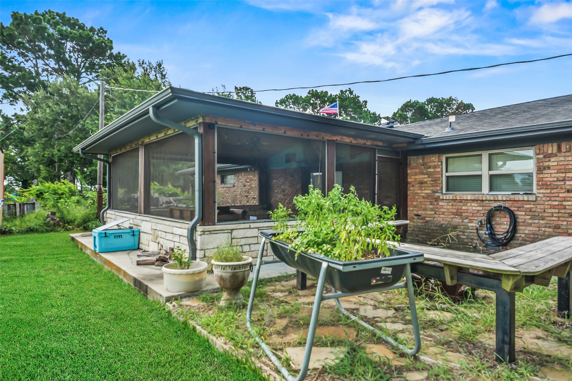 34366 Owens Road Hempstead, TX 77445 - Photo 27 of 46 Inviting covered patio with screened enclosure, ample space for outdoor seating and entertaining, and peaceful views overlooking the spacious backyard.