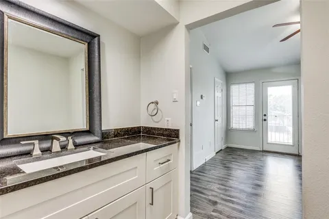 a bathroom with a granite countertop sink and a mirror