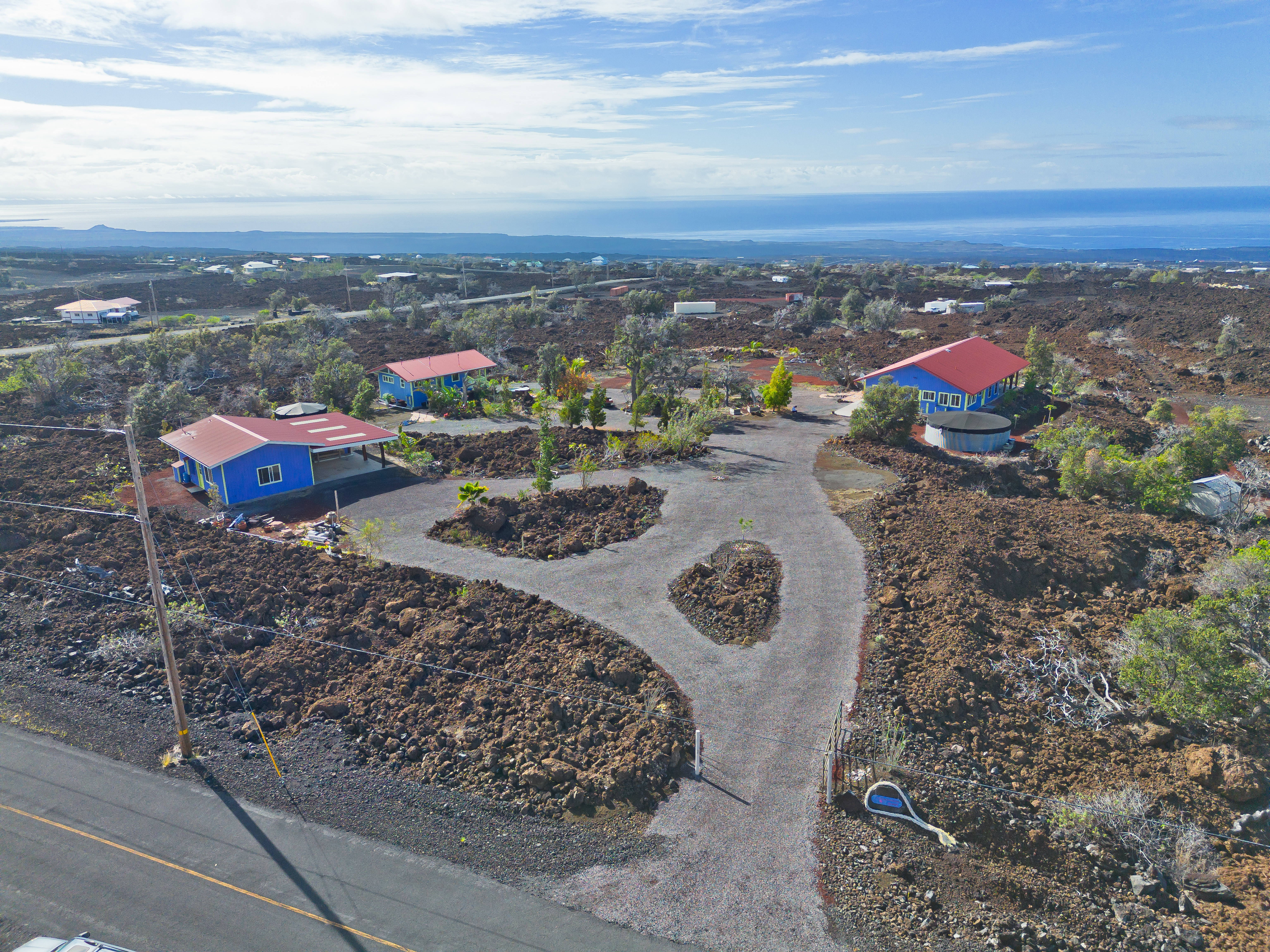 an aerial view of a city with lots of residential buildings and ocean view in back
