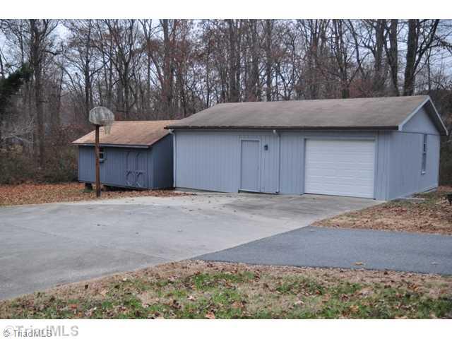 6711 Bastille Lane Oak Ridge, NC 27310 - Photo 16 of 16 Parking Lot/Garage. Single garage with workshop. 2 other outbuildings for WOW storage.