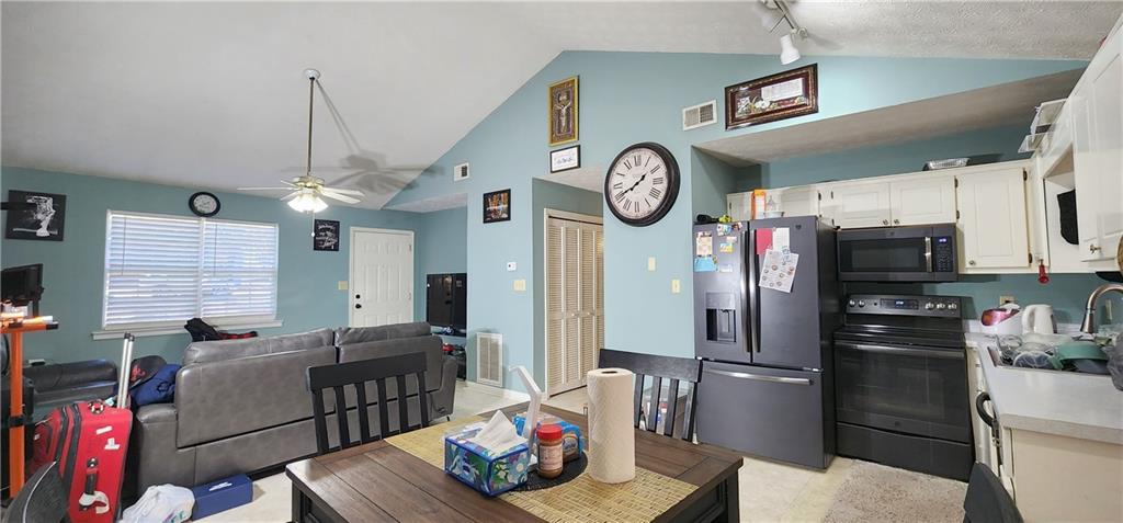 211 Brooks Lane Winder, GA 30680 - Photo 10 of 27 a kitchen with stainless steel appliances granite countertop a refrigerator a stove and a dining table with wooden floor