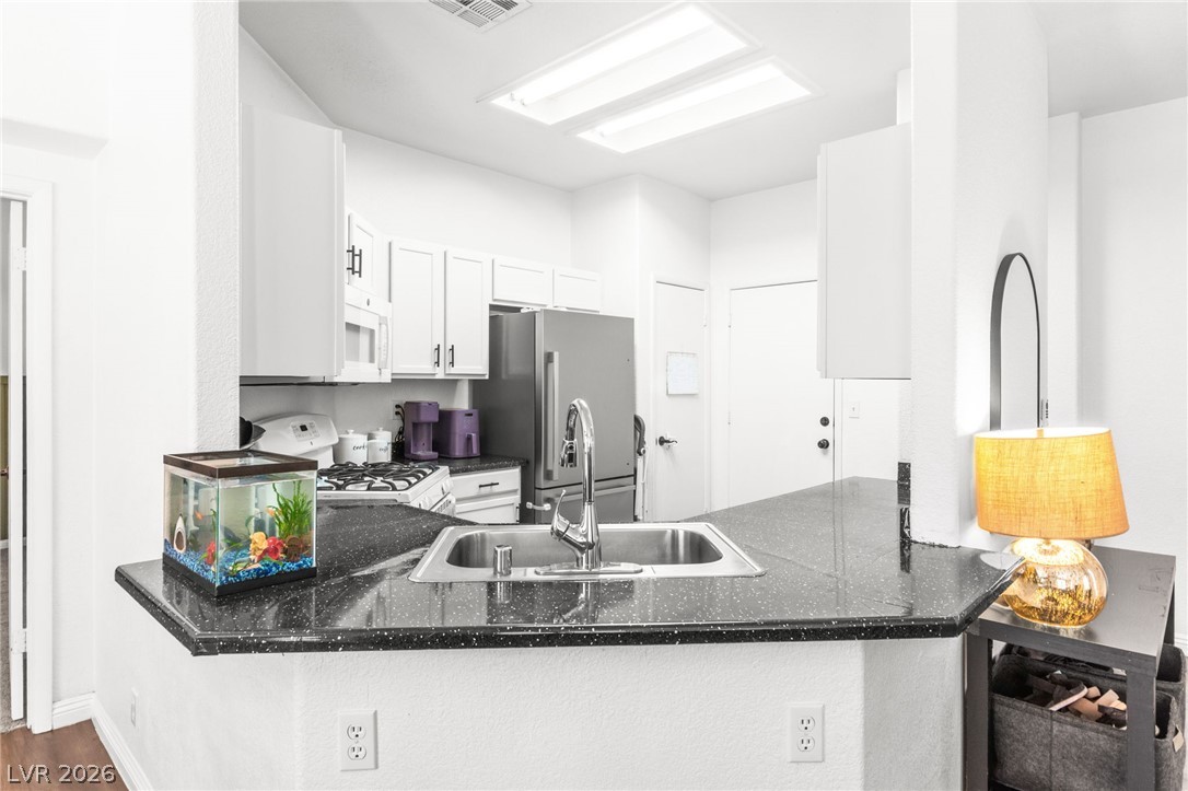 7353 Ridge Star Court Las Vegas, NV 89131 - Photo 13 of 36 Prepare meals effortlessly in this well-appointed kitchen featuring sleek countertops and modern appliances.