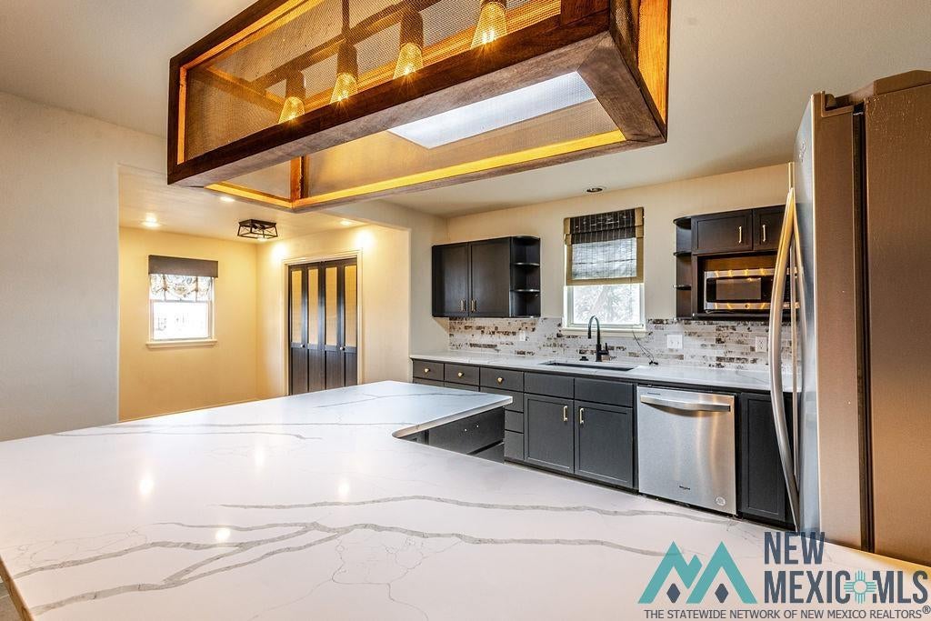 1131 Curry Road North Clovis, NM 88101 - Photo 19 of 69 Expansive kitchen island featuring a light-toned countertop with veining