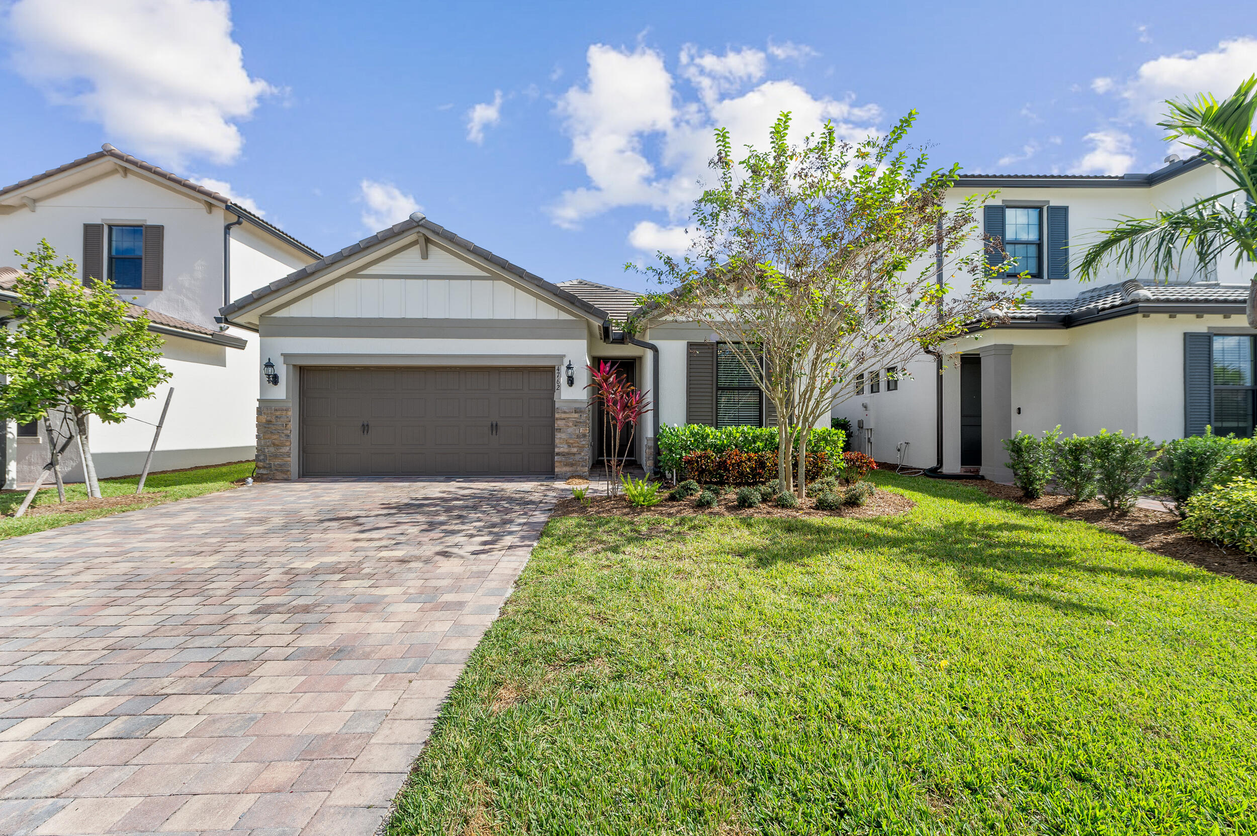 a front view of a house with a yard and a garage