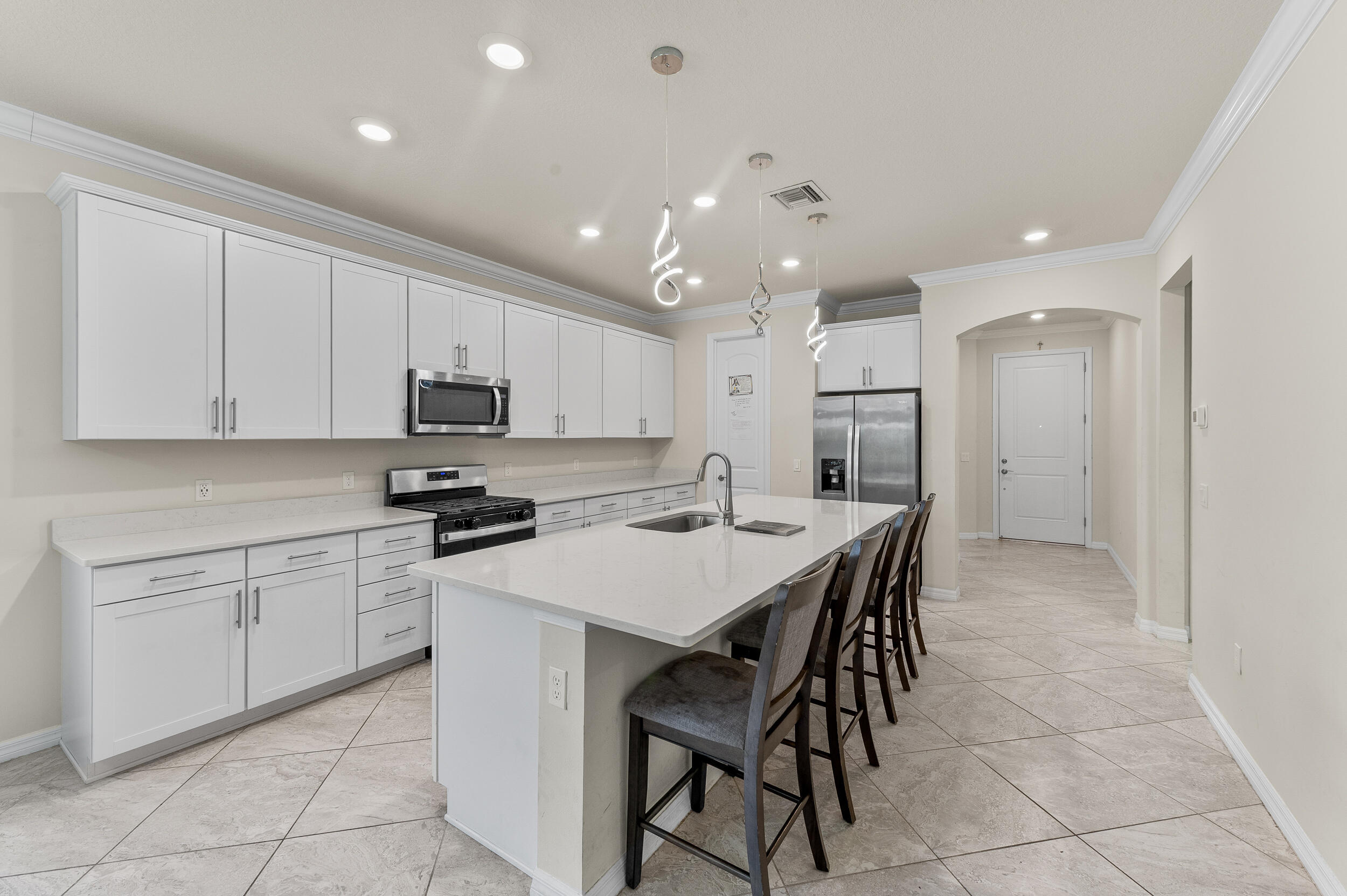 4762 Roldan Court Lake Worth, FL 33467 - Photo 8 of 33 a kitchen with a stove a sink dishwasher a refrigerator and white cabinets with wooden floor