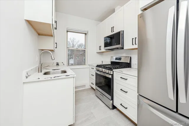 a kitchen with stainless steel appliances a sink stove and refrigerator