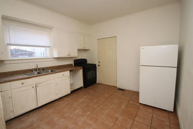 a kitchen with granite countertop a refrigerator and a sink