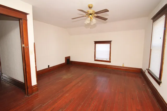 an empty room with wooden floor and window