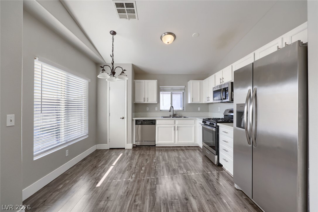 5985 High Steed Street, Unit 101 Henderson, NV 89011 - Photo 9 of 38 A well-lit kitchen with sleek stainless steel appliances awaits culinary endeavors.