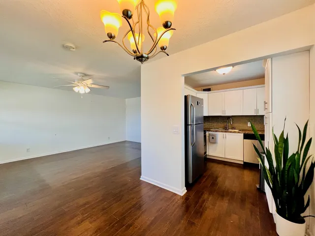a view of a room with wooden floor and a ceiling fan