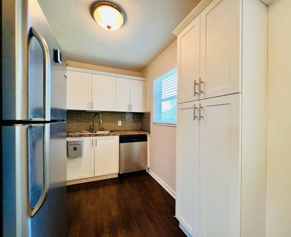 a kitchen with stainless steel appliances a refrigerator sink and cabinets
