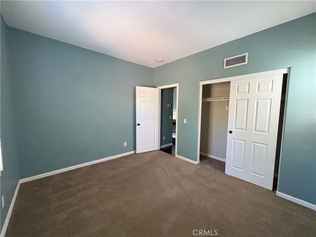 an empty room with closet and mirror