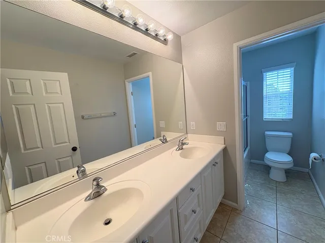 a white toilet sitting next to a bathroom sink and a tub