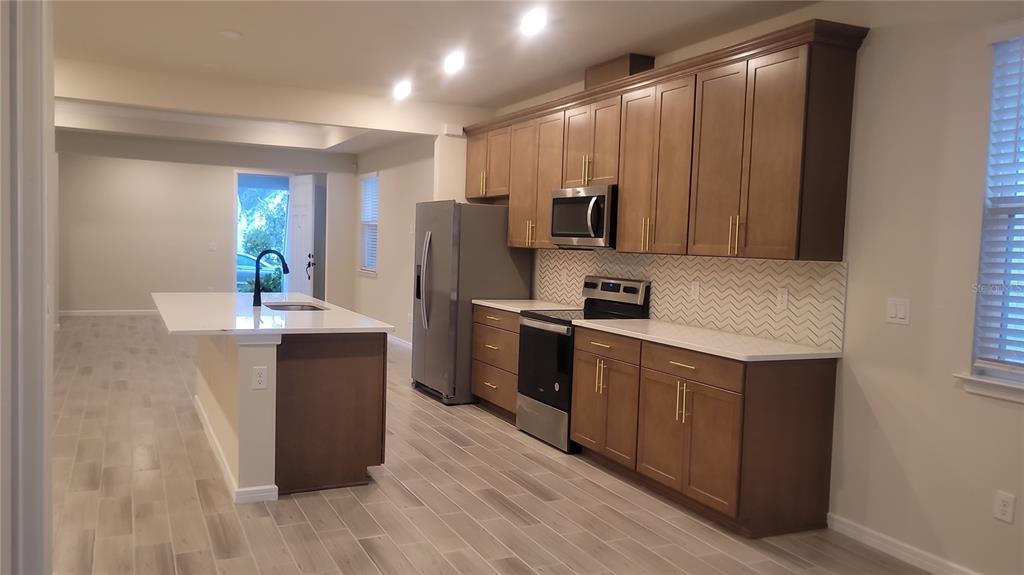 6558 Rover Way St. Cloud, FL 34771 - Photo 7 of 24 a kitchen with granite countertop a refrigerator and a sink