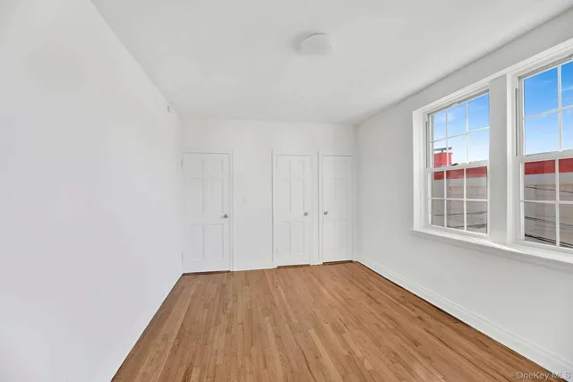 a view of a room with wooden floor and windows