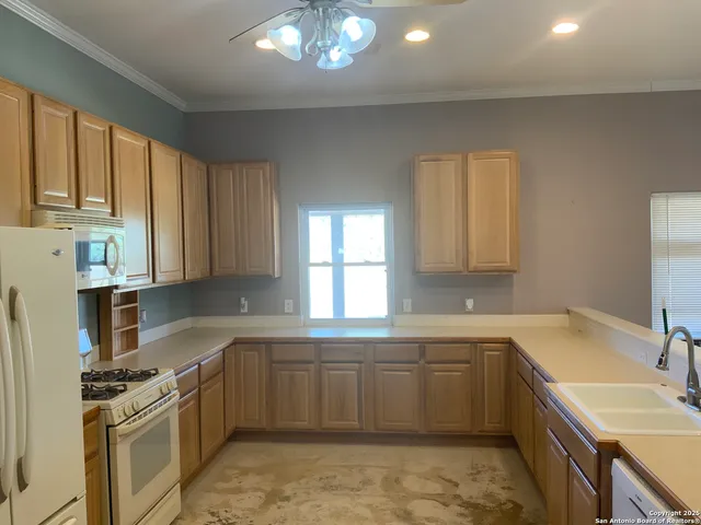 a kitchen with a sink stove top oven and refrigerator