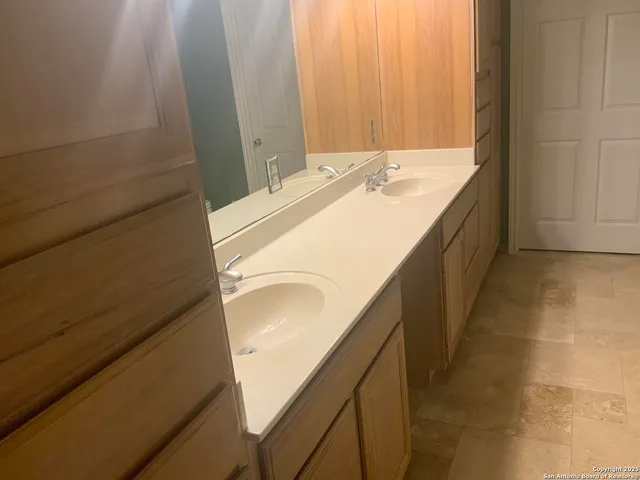 a en suite bathroom with a sink and a large mirror
