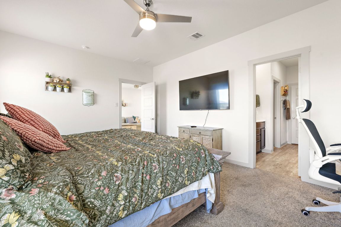 5001 Vanner Path Georgetown, TX 78626 - Photo 13 of 26 a bedroom with a bed and a flat tv screen on wall