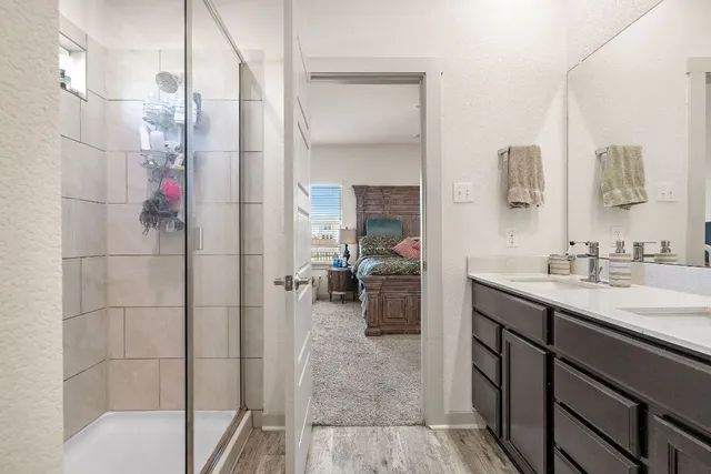 a en suite bathroom with a sink a mirror and shower