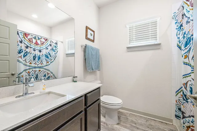 a bathroom with a sink a toilet and a window