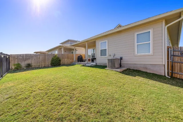 a view of a house with backyard and a tree
