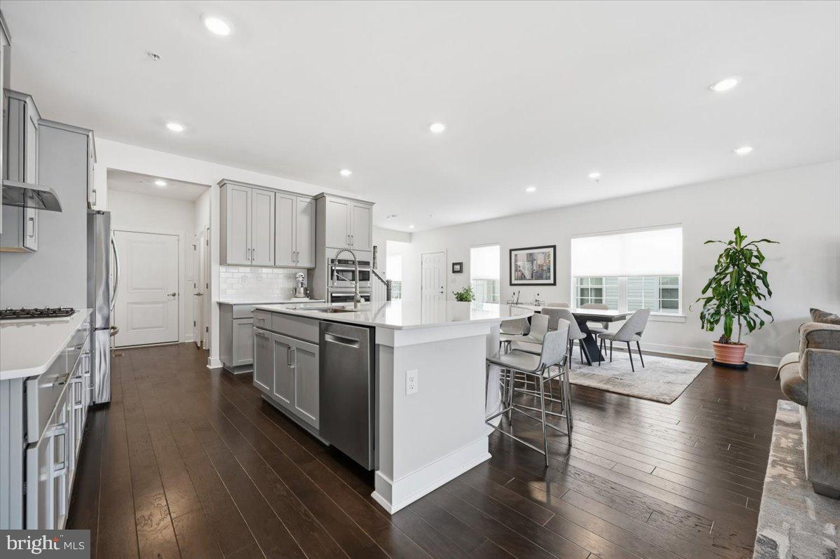 279 Red Leaf Lane Exton, PA 19341 - Photo 8 of 30 a kitchen with stainless steel appliances kitchen island wooden floors wooden cabinets and dining table