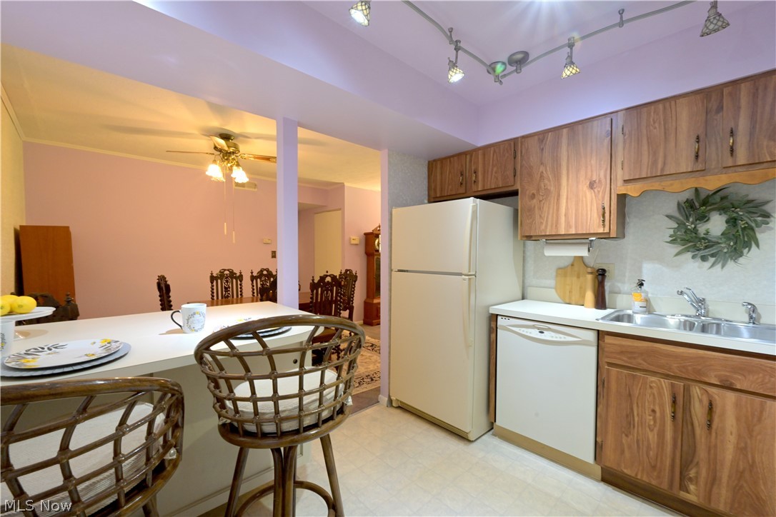 22962 Maple Ridge Road, Unit 206 North Olmsted, OH 44070 - Photo 10 of 33 Kitchen featuring ceiling fan, rail lighting, sink, white appliances, and light tile floors