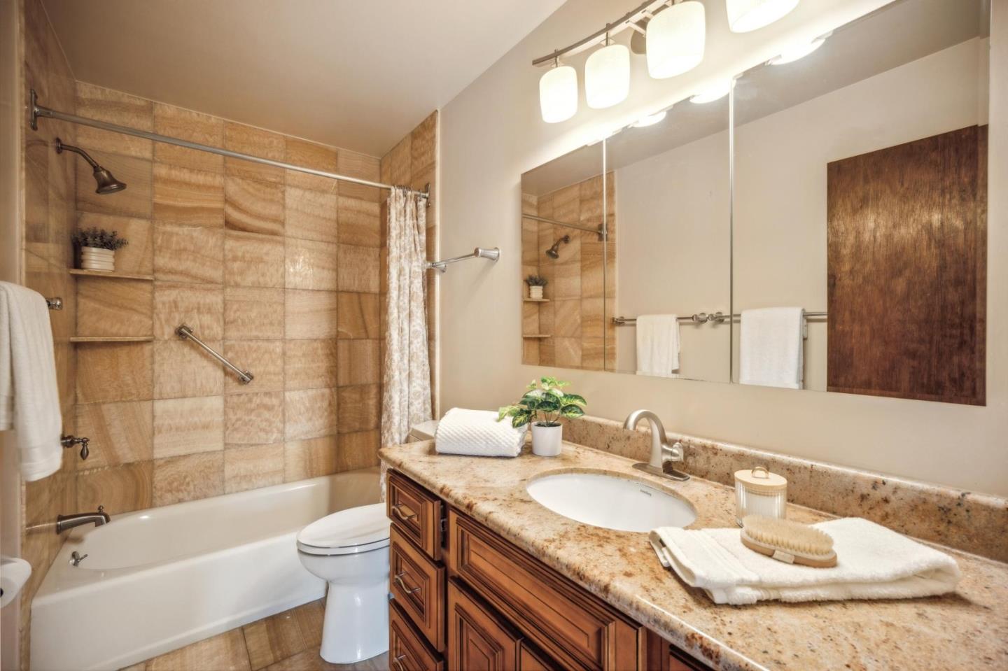 1261 Ocean View Boulevard Pacific Grove, CA 93950 - Photo 25 of 37 a bathroom with a granite countertop sink toilet mirror and shower