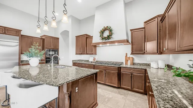 a kitchen with stainless steel appliances kitchen island granite countertop a sink and cabinets