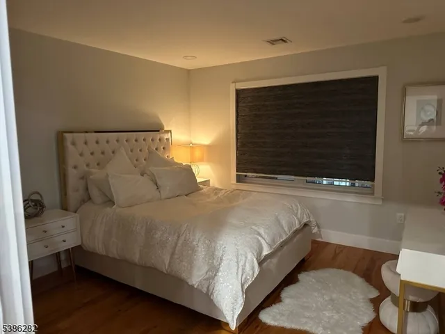 a large bed sitting in a bedroom next to a window